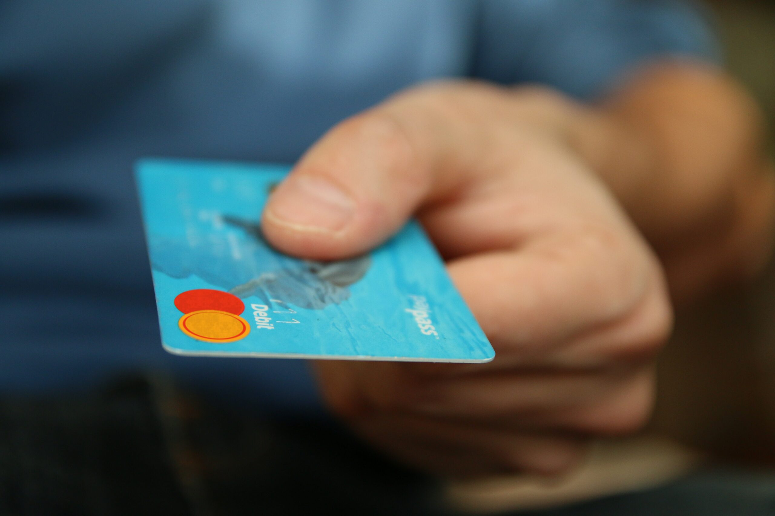 a person holding a blue credit card
